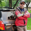 American filmmaker Martin Lisius stands next to his mud-covered Subaru Outback after a storm chase in Texas, 2013.