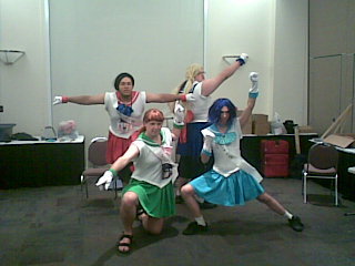 A crossplay photo of four men in Sailor Senshi uniforms, posing like the DBZ Ginyu Force.