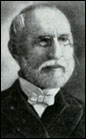 Head shot of balding gentleman with neatly trimmed white hair, moustache and beard, wearing glasses.