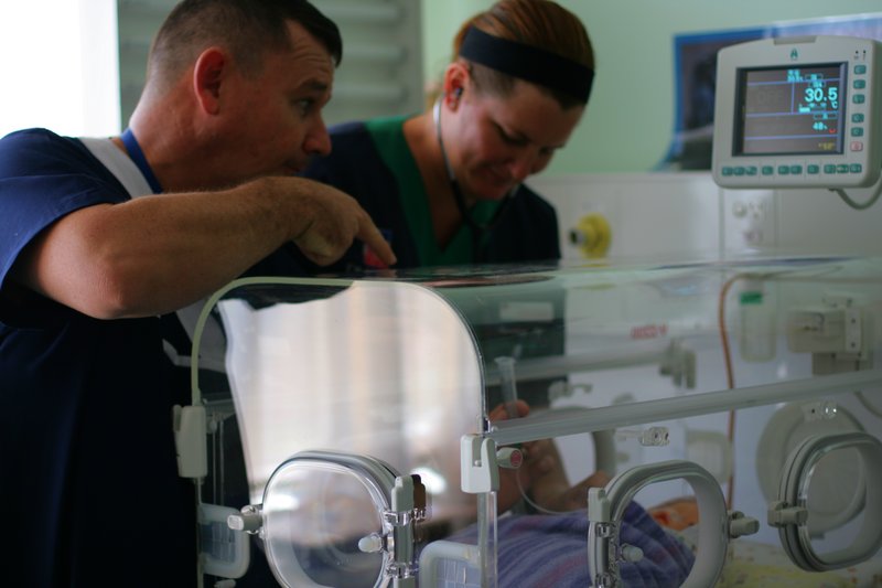 File:Sick baby with nurses.jpg