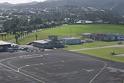 Whangarei Airport apron, with Quantum Aviation occupying the old control tower building, 2008. Visible to the right is also the old airport fire station. The Onerahi Volunteer Fire Station is visible in the background. The apron has since been resealed, with new markings and the terminal has been extended.