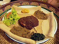 Typical Ethiopian and Eritrean cuisine: Injera (thin pancake-like bread) and several kinds of wat (stew)