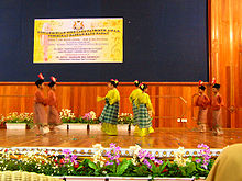 Young dancers during the Zapin dance, with two groups of boys surrounding a central group of girls, all in Malay dress