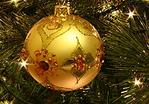 A golden bauble decorating a Christmas tree