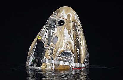 A SpaceX technician secures a strap around Crew Dragon Endeavour shortly after it splashed down in the Gulf of Mexico