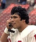 A picture of Jim Plunkett on a phone.