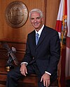 portrait of man sitting on the edge of a desk