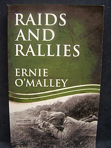 "Colour photograph of the front cover of Raids and Rallies by Ernie O'Malley, showing a picture of three hatted men armed with shotguns lying in ambush in a ditch"