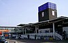 A brown-bricked building with a rectangular, dark blue sign reading "TOTTENHAM HALE" in white letters all under a clear, light blue sky