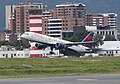 Delta 757 en carrera de despegue y al fondo la torre de control