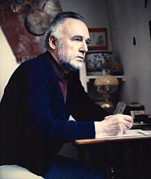 Jacques Breyer at his desk, staring to the right.