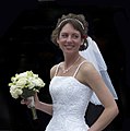 A bride holding a hand-tied bouquet, consisting of long-stemmed flowers.