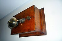 A small wooden box with a bell on the cover