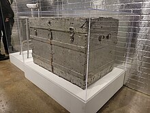 silver painted trunk within a Plexiglas vitrine