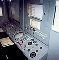 Battery Control Officer operating position with the acquisition radar operator on the left and on the right the computer operator. And in front the plotting boards.