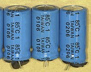 Failed electrolytic capacitors with swollen can tops and expelled rubber seals, dates of manufacture "0106" and "0206" (June 2001 and June 2002)