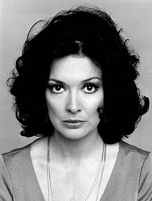 A black-and-white photo of a 38-year-old woman with curly dark hair looking into the camera