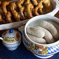 Traditional Weisswurst meal, served with sweet mustard and a soft pretzel.