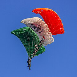 3 members of Akash Ganga skydiving team of the IAF carrying the Indian Flag.