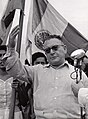 Foto del Gral. Miguel Henríquez Guzmán candidato presidencial del Partido Constitucionalista Mexicano en 1952. Nótese al fondo la bandera y el escudo con la inscripción Estados Unidos Mexicanos.