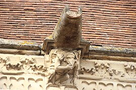 Detail of another marmouset sculpture, holding its chin and featuring a gargoyle above it.