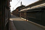 A small street lined by wooden two-storied houses.