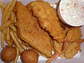 Typical American seafood with Fried fish, shrimp, hush puppies, and fries.