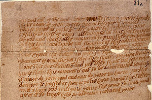 A damaged and aged piece of paper, or parchment, with multiple lines of handwritten English text.