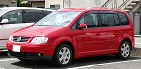 Front-three-quarter view of a five-door car with a raised roofline, flush headlights, front foglamps, door mirrors with integrated turning indicator lights, alloy wheels, and bars for attaching a roof rack