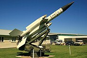 Photo shows a white surface-to-air missile in a museum setting.