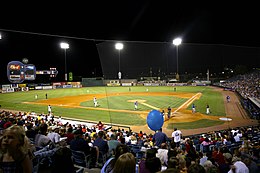 The green baseball field illuminated for a night game