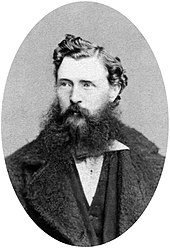 A dark-haired man with a scruffy beard