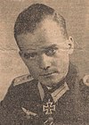 A man wearing a military uniform with an Iron Cross displayed at the front of his uniform collar.