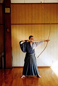 Professor Inagaki Genshiro with a bow and arrow in a dōjō of the University of Tsukuba