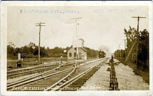 A postcard of a small structure at a railroad junction