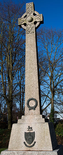 Monumental cross of granite in an outdoor setting with bare trees