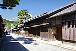 Two storied wooden houses next lining a street.