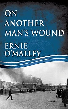 "Colour photograph of the front cover of On Another Man's Wound by Ernie O'Malley, showing a picture of buildings on fire near a bridge"