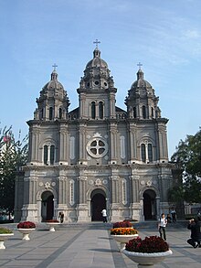 The facade of a Romanesque-style church with three spires