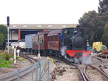 Locomotive Peronne hauls a special train on narrow-gauge track at the museum; track on the left is for miniature train rides around the site.