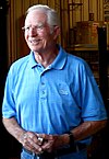 Jim Hall wearing rectangular glasses and a baby blue T-shirt with the top button undone