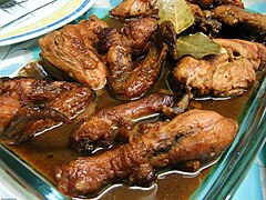 Adobo is typically pork or chicken, or a combination of both, is slowly cooked in vinegar, cooking oil, crushed garlic, bay leaf, black peppercorns, and soy sauce, and often browned in the oven or pan-fried afterward to get the desirable crisped edges.