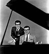 Ferrante and Teicher smiling behind a piano