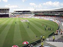 Kensington Oval with players in the ground; empty stands are also visible.