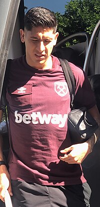 Picture of Edson Alvarez getting of the West Ham United team bus wearing the classic West Ham colors of purple and light blue.