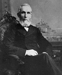 Monochrome photograph of Alexander Mackenzie sitting in a chair