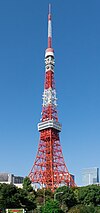 View of an orange and white lattice frame; the structure curves and widens near the bottom and comes to a point at the top