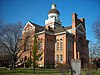 A brick Romanesque Revival courthouse highlighted against a deep blue sky