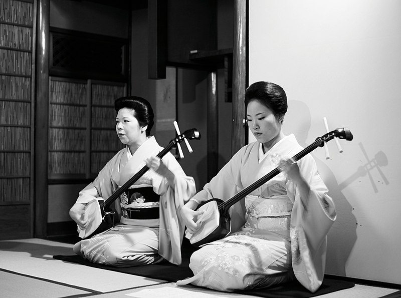 File:Two geishas playing shamisen.jpg