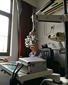 An elderly woman is undergoing an eye examination at a hospital